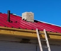 red tin roof with white brick chimney and ladder